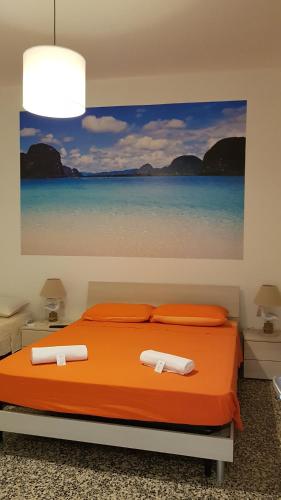 ein Schlafzimmer mit einem Bett mit einem Gemälde des Ozeans in der Unterkunft Bed Rho Fiera - Milano Galeazzi in Rho