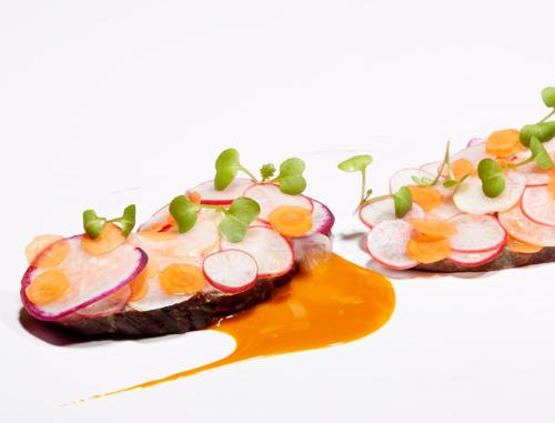 two plates of food with sauce and vegetables on them at Malerwinkl Restaurant + Kunsthotel in Hatzendorf