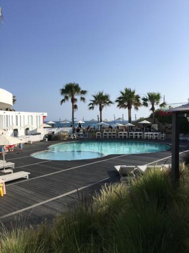 a swimming pool with chairs and palm trees at Vale Do Lobo 935 in Loulé
