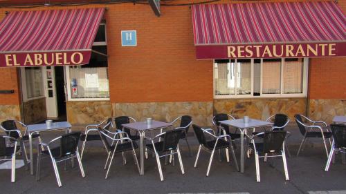 a group of tables and chairs in front of a restaurant at Hostal Restaurante El Abuelo in Trobajo del Camino