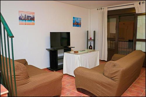 コニル・デ・ラ・フロンテーラにあるApartamento Duplex en Conilのリビングルーム(椅子2脚、テレビ付)