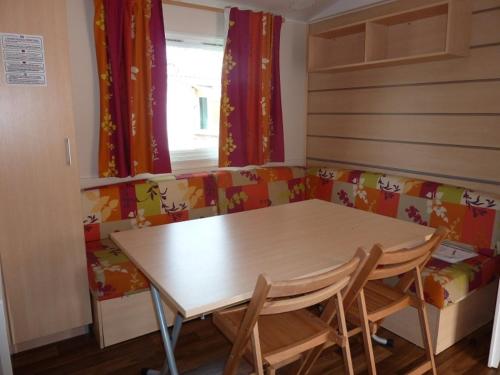 a table and chairs in a room with a couch at Mobile Home Hanse in Boofzheim