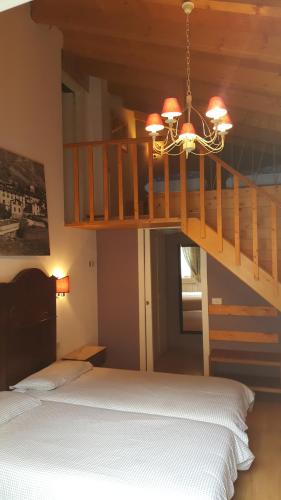 a bedroom with a bunk bed and a chandelier at Trattoria Traversi in Berbenno di Valtellina