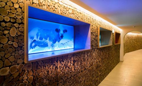 a tv mounted on a wall with logs at Lifestyle Hotel eder in Maria Alm am Steinernen Meer