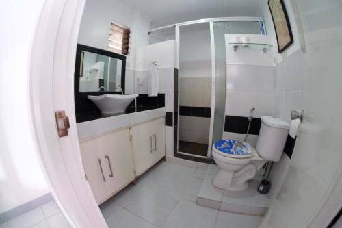 a bathroom with a toilet and a shower and a sink at L & M Hearthstones Lodge in Oslob