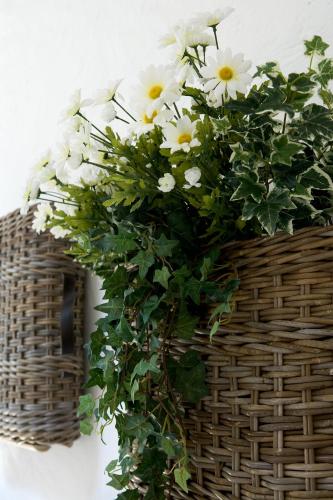 a basket filled with white flowers on a wall at Borgo Dei Conti Della Torre in Morsano al Tagliano