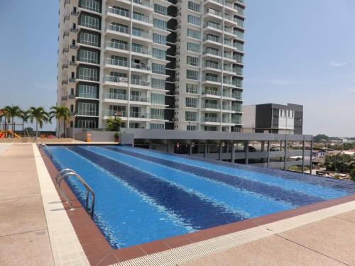 uma piscina em frente a um grande edifício em Sekinchan Happiness Homestay em Sekincan