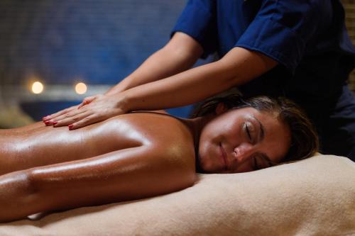 a woman getting a massage from a therapist at Les Terrasses d'Atlanthal in Anglet