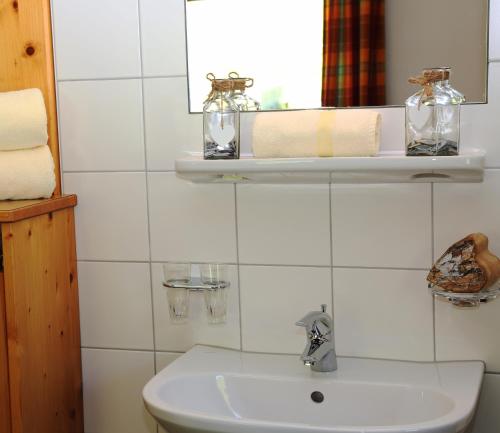 a white bathroom with a sink and a mirror at Haus Zeinissee in Galtür