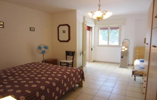 レウカにあるBilocale con spazio verdeのベッドルーム1室(ベッド1台、椅子、窓付)