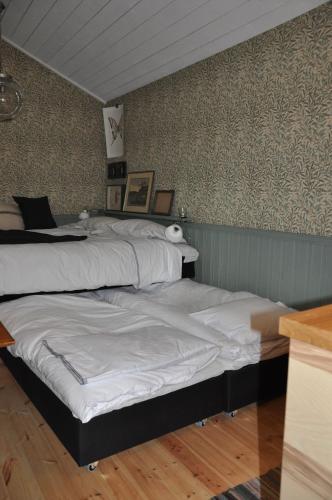2 Betten in einem Zimmer mit einer Wand in der Unterkunft Håkesgård Bed&Garden in Veddige