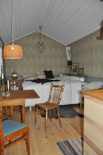 Håkesgård Bed&Garden في Veddige: غرفة نوم بسرير وطاولة وكرسي