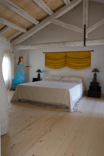a bedroom with a bed and a woman in a blue dress at Borgo Dei Conti Della Torre in Morsano al Tagliano