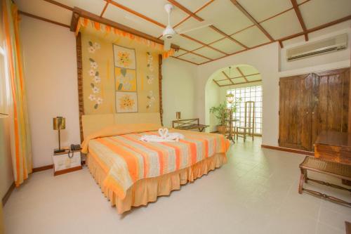 a bedroom with a bed with an orange bedspread at Sigiriya Village in Sigiriya
