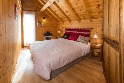 Saint-Michel-de-ChaillolにあるChalets Shangrilaの木造キャビン内のベッドルーム1室(大型ベッド1台付)