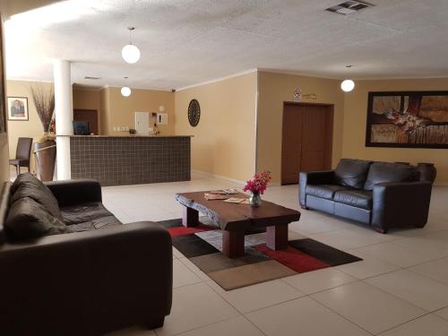 a living room with a couch and a coffee table at Rocha's Hotel in Oshakati