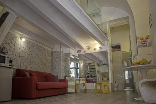 a living room with a red couch and yellow tables at Dammuso di Ponente Ortigia in Siracusa