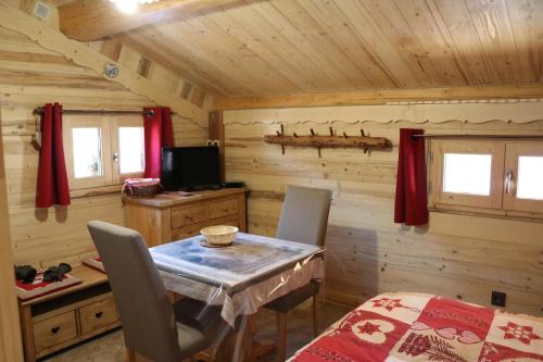 ein Esszimmer mit einem Tisch in einer Blockhütte in der Unterkunft Le Refuge des Marmottes in Arêches