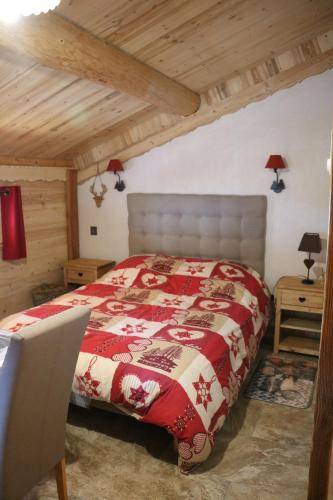 une chambre avec un lit avec une couverture rouge dans l'établissement Le Refuge des Marmottes, à Arêches