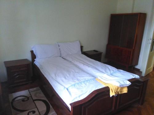 - un lit avec des draps et des oreillers blancs dans une chambre dans l'établissement Apartament NORA, à Braşov