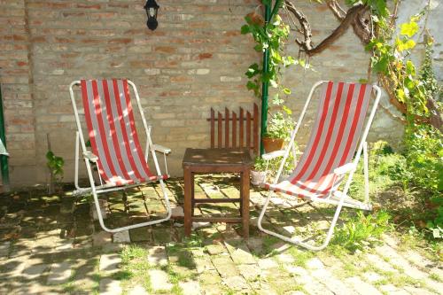 two chairs and a table in front of a brick wall at Sobe Gajić Sremski Karlovci in Sremski Karlovci