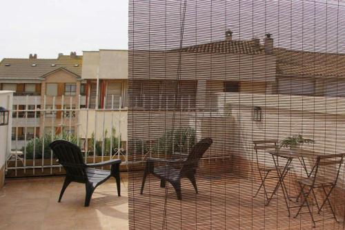 a patio with a table and chairs on a balcony at Alojamientos Dezerto Bardenas in Arguedas