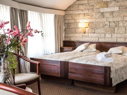 um quarto de hotel com uma cama e uma cadeira em Hotel Restaurant La Porte d'Octodure em Martigny-Ville