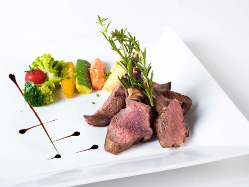 a plate of food with meat and vegetables on it at Hotel Restaurant La Porte d'Octodure in Martigny-Ville