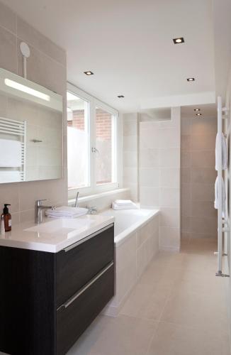 a bathroom with two sinks and a large mirror at NEW Appartment Zandvoort! in Zandvoort