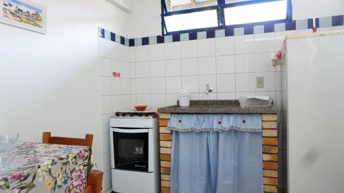 a small kitchen with a counter and a sink at Pousada Barratur in Florianópolis