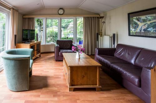 Chalet vakantie Wageningen في فاخينينغين: غرفة معيشة مع أريكة وطاولة قهوة