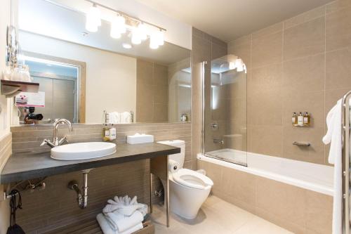 uma casa de banho com um lavatório, um WC e uma banheira em The Sidney Pier Hotel & Spa em Sidney