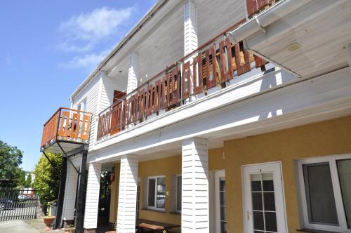 a building with a balcony on the side of it at Dom wczasowy Maja in Dźwirzyno