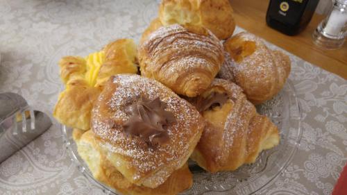 a bunch of pastries on a glass plate on a table at Villa Mandrioli in Cecina
