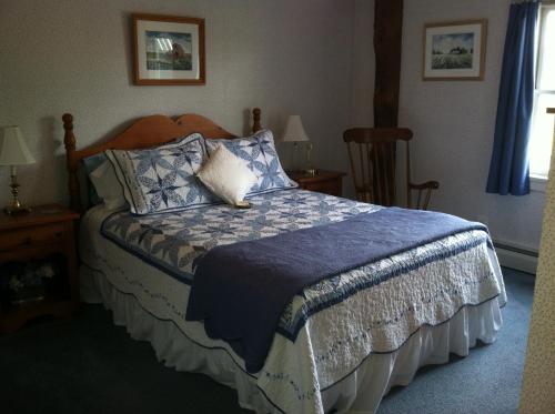a bedroom with a bed with a blue comforter at The South Glenora Tree Farm in Dundee