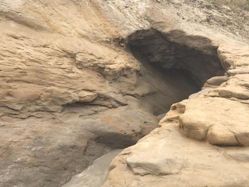 a cave in the side of a rocky cliff at BlackPoint in Ballenita