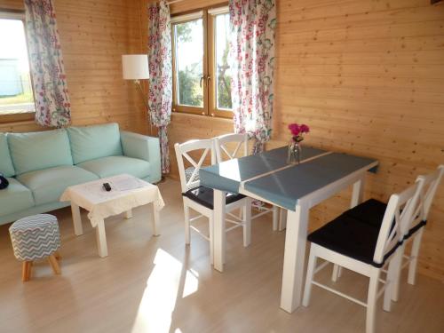 a living room with a couch and a table and chairs at Cztery Pory Roku in Trzęsacz