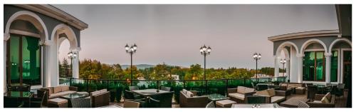 a restaurant with chairs and tables on a balcony at Tskaltubo Hotel Prometheus in Tskaltubo