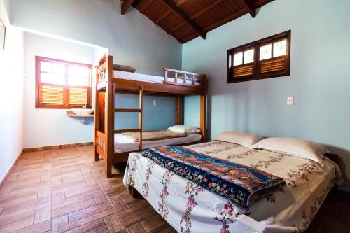 Hostel Rua Direita Pirenópolis في بيرينوبوليس: غرفة نوم مع سرير وسرير بطابقين في غرفة