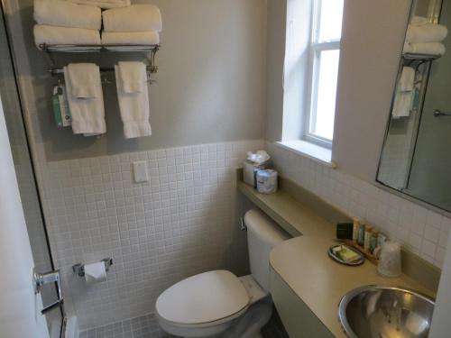 a bathroom with a toilet and a sink and a mirror at The EO Inn - Downtown Orlando in Orlando