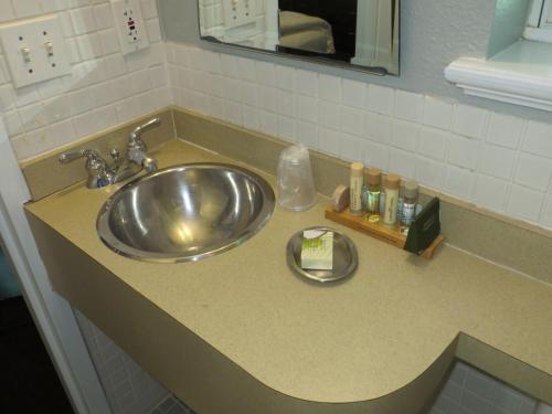 a bathroom counter with a sink and a mirror at The EO Inn - Downtown Orlando in Orlando