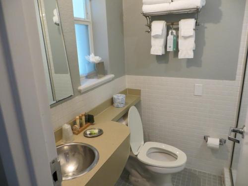 a small bathroom with a toilet and a sink at The EO Inn - Downtown Orlando in Orlando