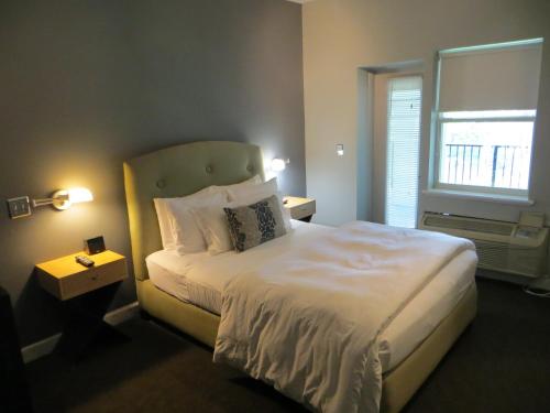 a bedroom with a white bed with a window at The EO Inn - Downtown Orlando in Orlando