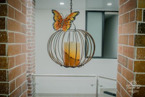 a butterfly chandelier hanging from a brick wall at Casa del Sol in Villavicencio