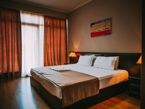 a bedroom with a large bed in a room at Tskaltubo Hotel Prometheus in Tskaltubo