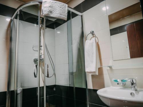a bathroom with a shower and a sink at Tskaltubo Hotel Prometheus in Tskaltubo