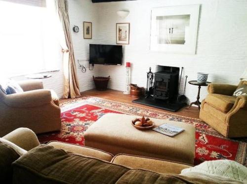 a living room with a couch and a fireplace at TopHeavy Cottage Mevagissey in Mevagissey