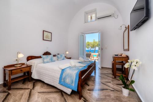 a bedroom with a bed and a tv on a wall at Aronia Villa in Imerovigli