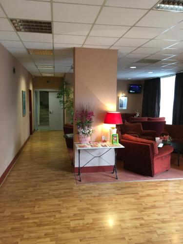a lobby with couches and a table with a lamp at Hotel Dorele in Montargis