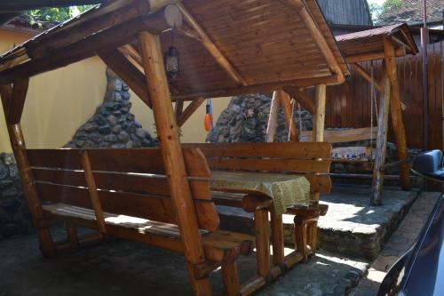 a wooden bench sitting in front of a building at Casa Maria in Şura Mică